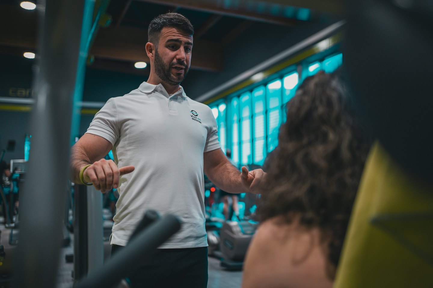 Personal trainer die een oefening demonstreert aan een klant in een sportschool.